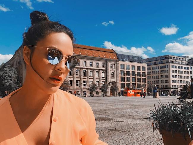 Η KC Concepción φοράει γυαλιά ηλίου Ray Ban στον έντονο ήλιο στο Gendarmenmarkt Berlin τον Μάιο του 2018