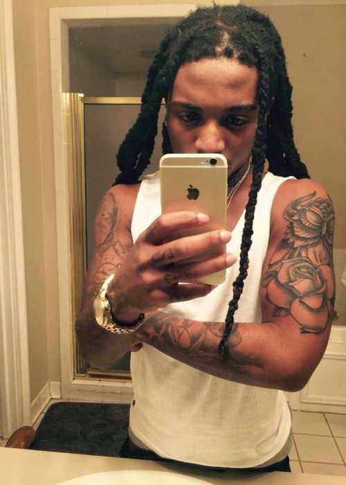 Rapperen Jacquees i et badeværelses selfie, der viser sine kropstatoveringer