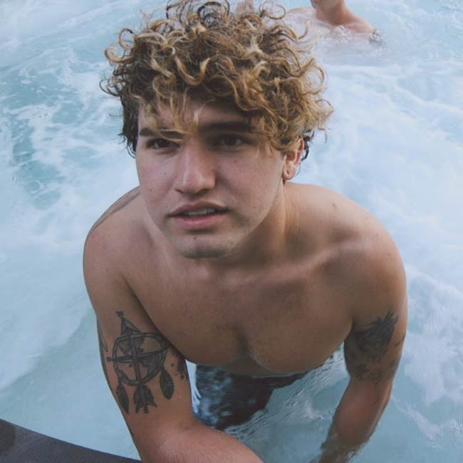 JC Caylen skjorteløs i en pool som set i 2016