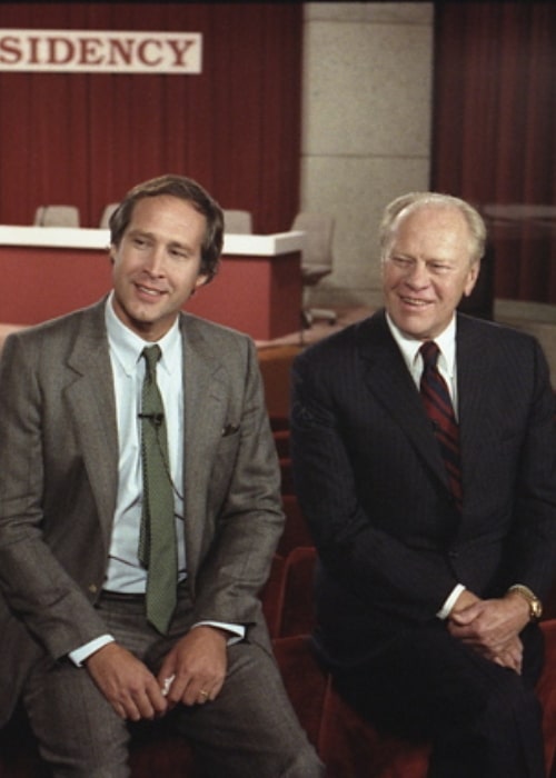 Chevy Chase (Venstre) og Gerald Ford sidder før konferencen om humor og formandskab afholdt på Gerald R. Ford Museum i 1986