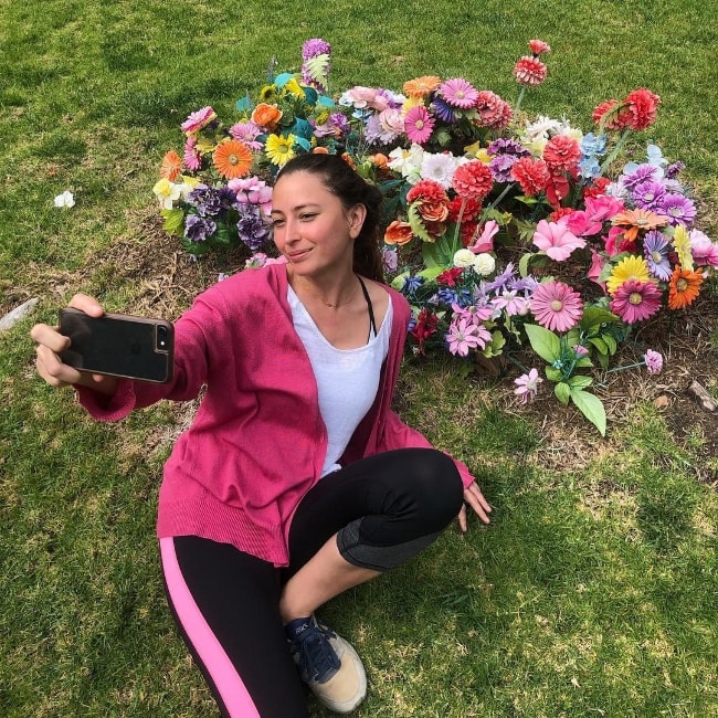 Fabianne Therese nähdään otettaessa selfieä kauniiden kukkien kanssa maaliskuussa 2019