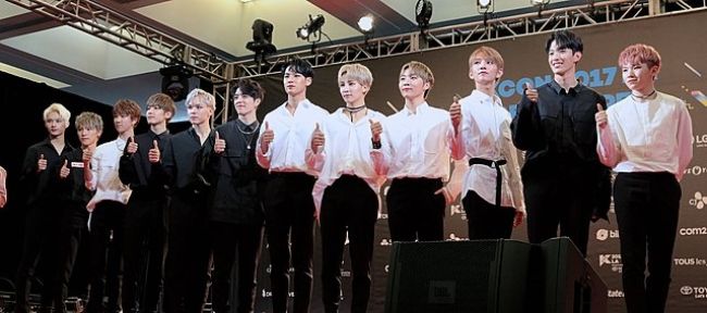 Woozi (ekstrem høyre) sett sammen med sine sytten bandkamerater på KCON 2017 i LA