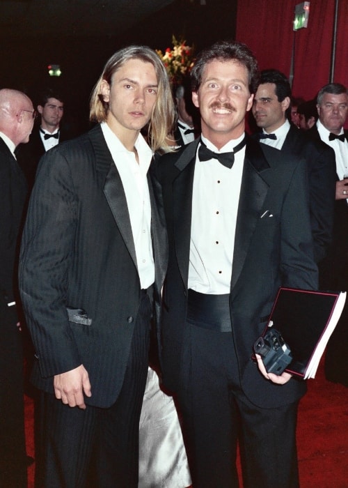 River Phoenix (venstre) set, mens han poserede for kameraet sammen med en ventilator ved 61. Academy Awards, 29. marts 1989 - Governor's Ball