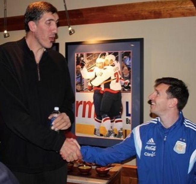 Ο Gheorghe Muresan όπως φαίνεται ενώ δίνει τα χέρια με τον Αργεντινό επαγγελματία ποδοσφαιριστή, Lionel Messi