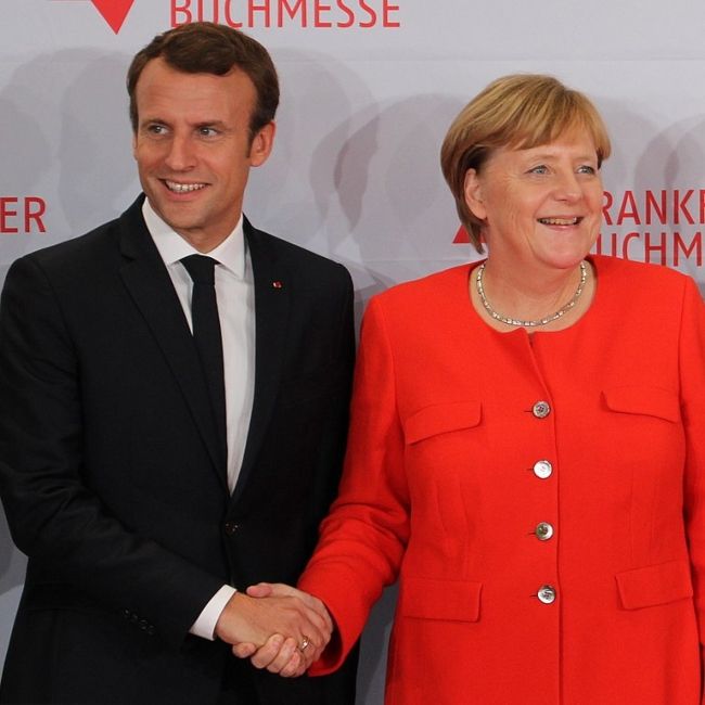 Emmanuel Macron håndhilser på Tysklands forbundskansler Angela Merkel i oktober 2017