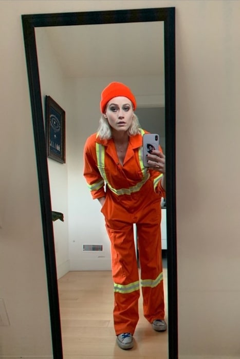 Olivia Taylor Dudley, jak je vidět při pořizování zrcadlové selfie v kombinéze stavebních dělníků v říjnu 2019