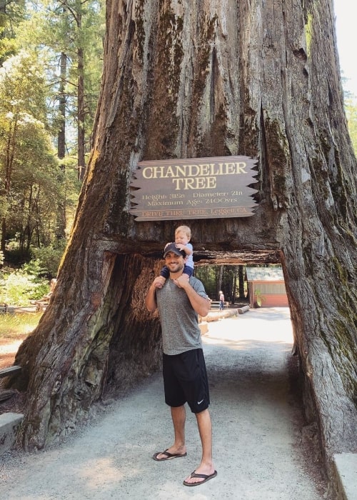 Tanner Tolbert på Drive-Thru Tree Park har det sjovt at stå under et stort træ med en lille baby i juni 2020