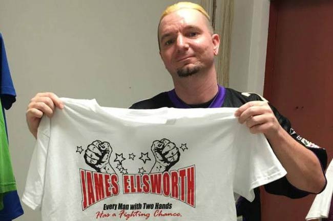 Ο Τζέιμς Έλσγουορθ δείχνει το μπλουζάκι του με το εμπόρευμα WWE